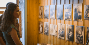 A woman stands viewing displayed historical black and white photographs