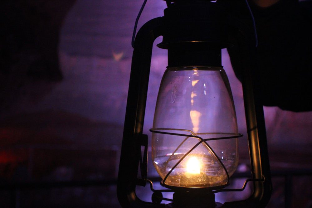 A lighted latern held in a dark cave