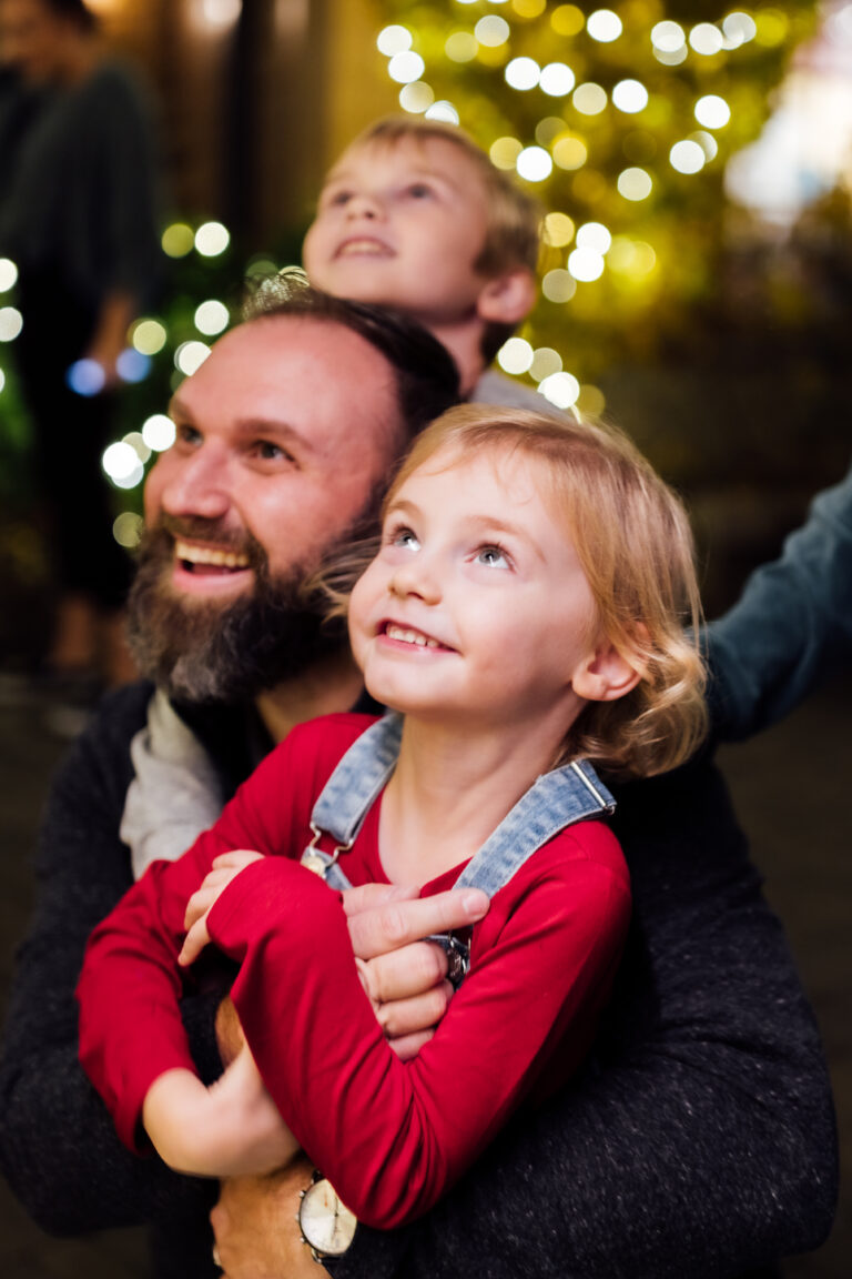 Man and child look in wonder at a Christmas tree