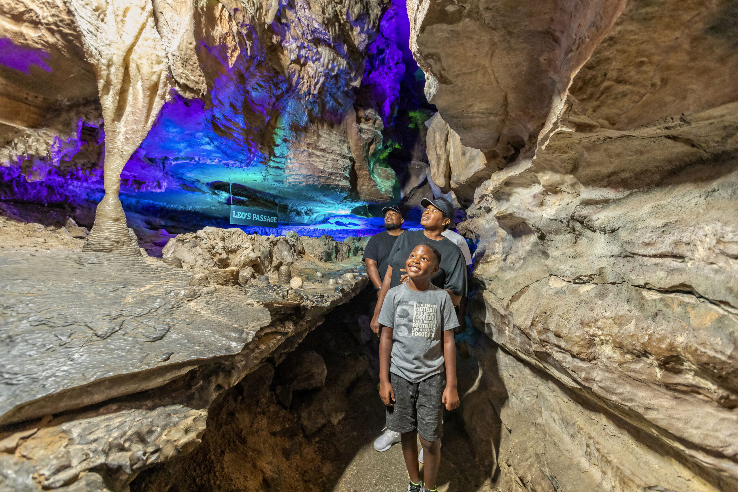 A family walks admiring the caves next to a sign reading 