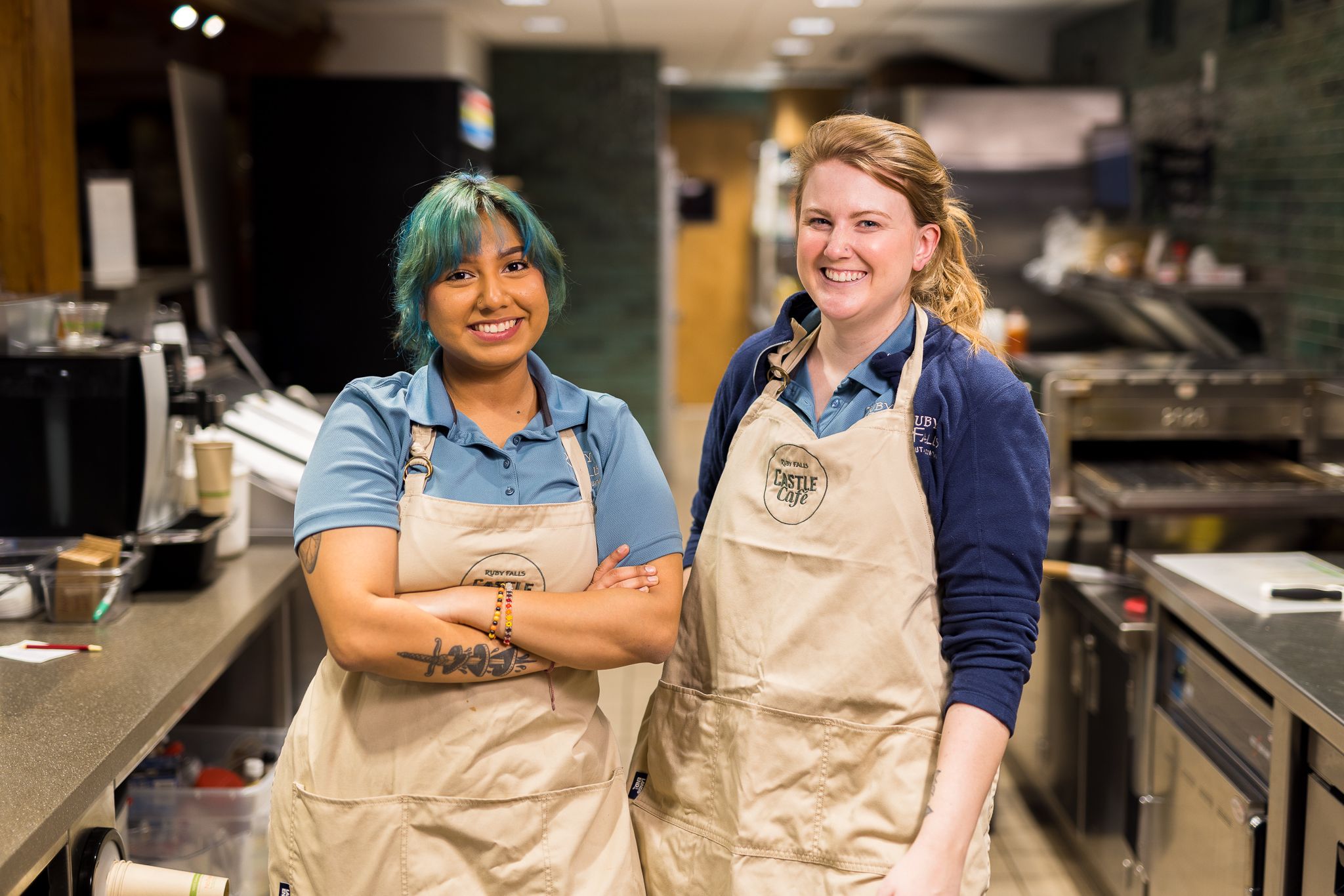 Two kitchen employees smile at the camera
