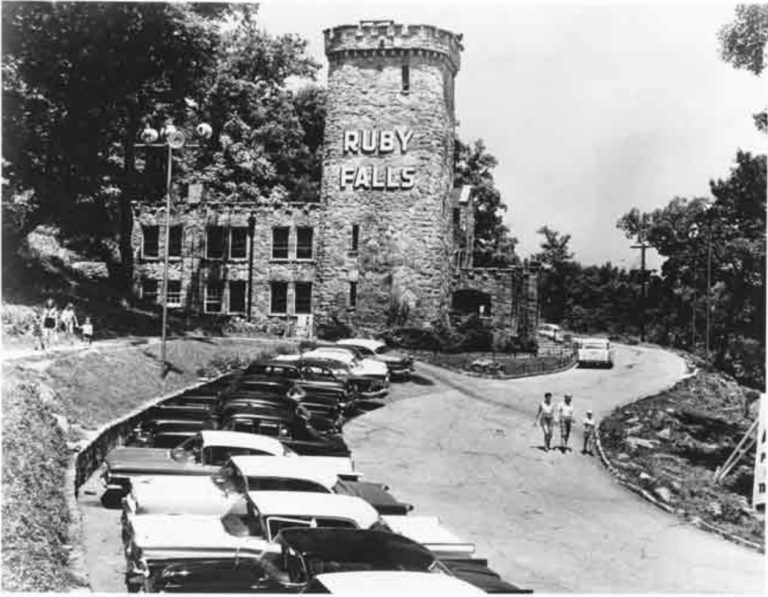 Historic Ruby Falls castle with vintage cars in parking lot