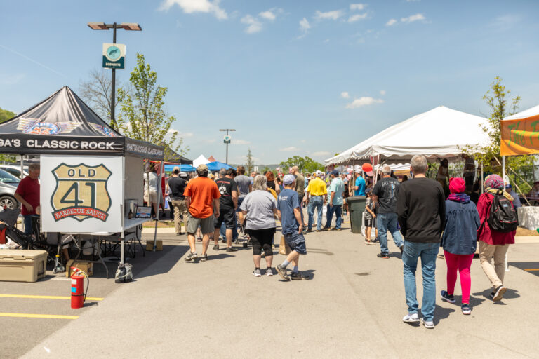 People walking between vendor tents at an event