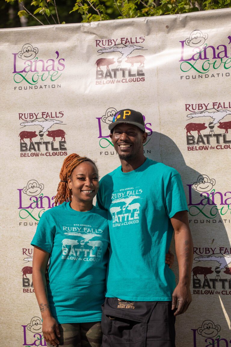 Two people wearing matching teal shirts