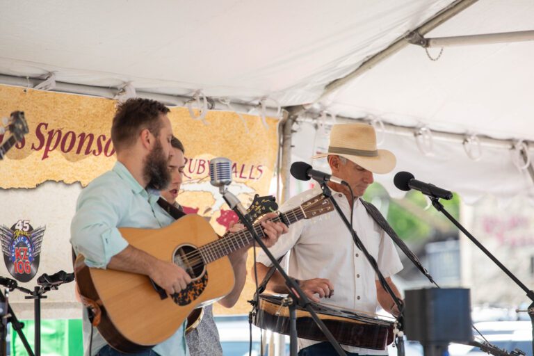 Person playing guitar and singing at an event