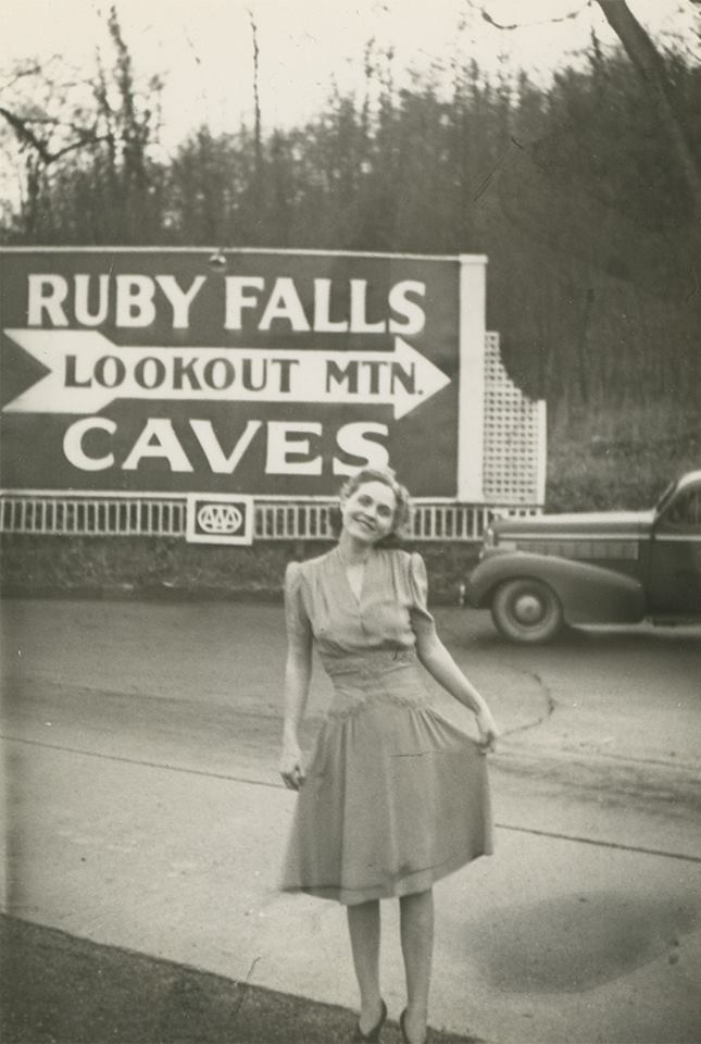 Vintage photo of a woman in front of the Ruby Falls sign