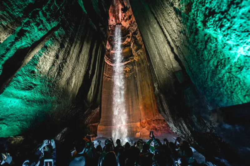 A group of people touring Ruby Falls with the waterfall in the background. 