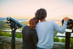 Couple standing by viewfinders overlooking Chattanooga