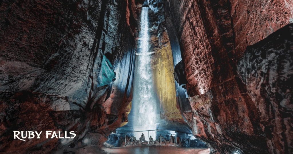 Ruby Falls Waterfall thunders from season rain showers. The limestone around the waterfall is colorfully lit with LED lights.