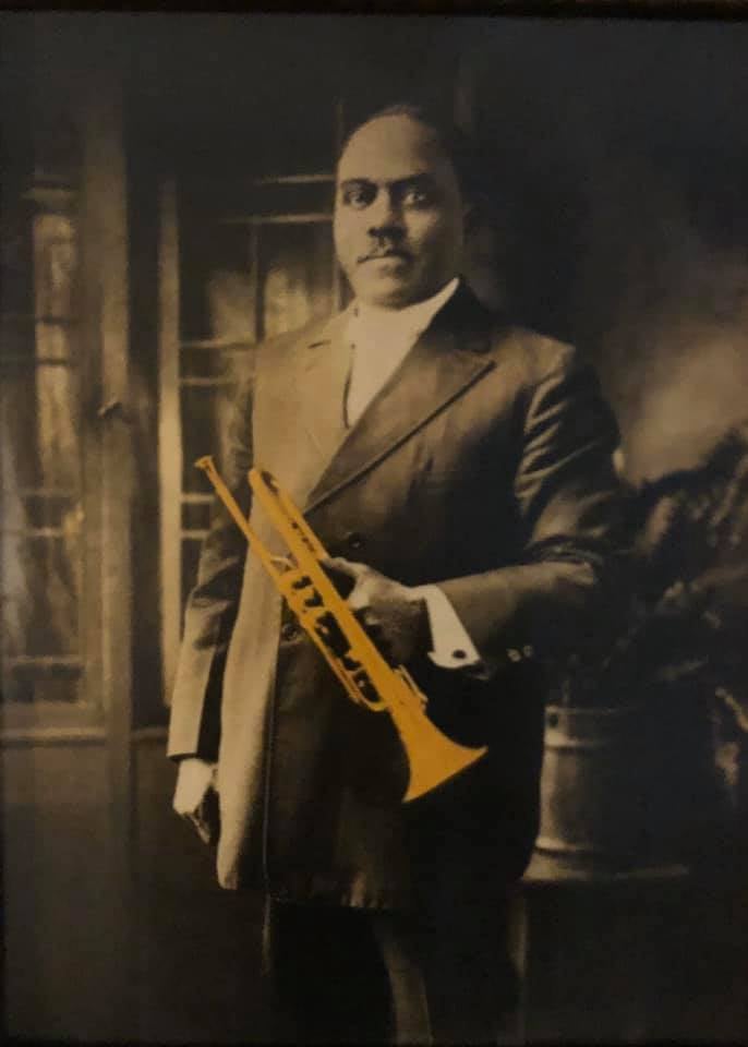Colorized vintage photo of G W Franklin holding an instrument